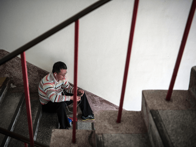 XINGANG, TAIWAN - APRIL 17: A man checks his phone as he rests at a pilgrims rest house ne