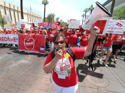 Educator Kelley Fisher leads Arizona teachers through downtown Phoenix on their way to the State Capitol during a rally for the #REDforED movement on April 26, 2018 in Phoenix, Arizona. Teachers state-wide staged a walkout strike on Thursday in support of better wages and state funding for public schools. (Photo …