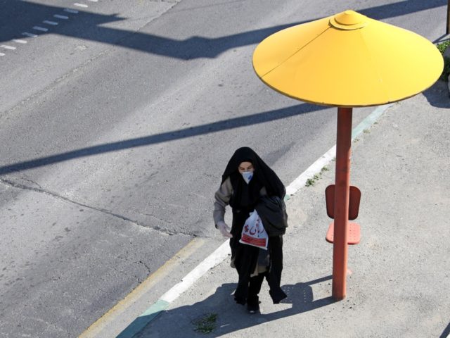 An Iranian pedestrian walks while wearing a protective mask in Tehran on March 10, 2020 amid the spread of coronavirus in the country. - Iran today reported 54 new deaths from the novel coronavirus in the past 24 hours, the highest single-day toll since the start of the country's outbreak. …