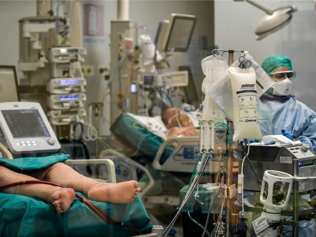 In this photograph taken from behind a window, doctors work on Covid-19 patients in the intensive care unit of San Matteo Hospital, in Pavia, northern Italy, Thursday, March 26, 2020. The San Matteo hospital is where Patient 1, a 38-year-old Unilever worker named Mattia, was kept since he tested positive …