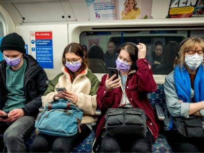 Commuters wear masks as a precaution whilst travelling on a London Underground metro train in the morning in central London on March 18, 2020 as people take precautions amid the coronavirus outbreak. - The British government will on Wednesday unveil a raft of emergency powers to deal with the coronavirus …