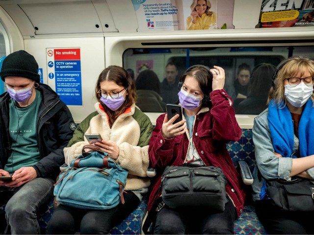 Commuters wear masks as a precaution whilst travelling on a London Underground metro train