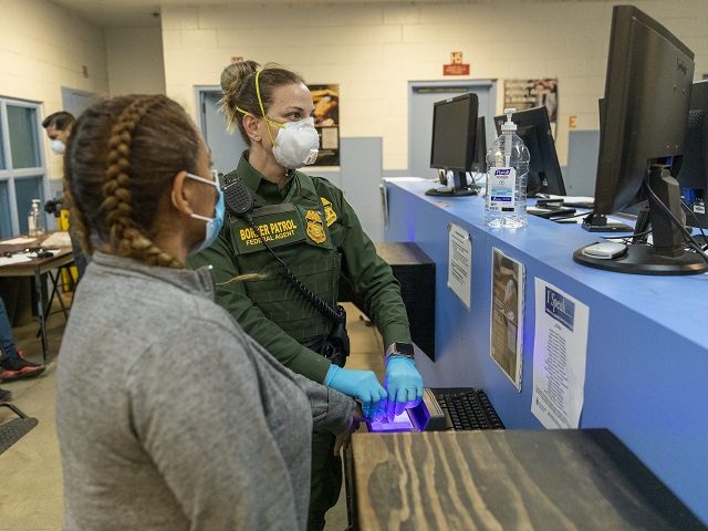 A U.S. Border Patrol agent conducts a biometric background investigation on an illegal alien. (Photo: U.S. Border Patrol/San Diego Sector)