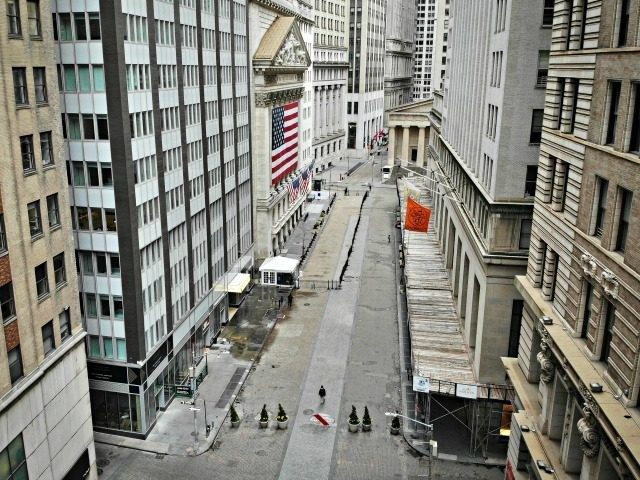 A lone pedestrian wearing a protective mask walks past the New York Stock Exchange as COVID-19 concerns empty a typically bustling downtown area, Saturday, March 21, 2020, in New York. New York Gov. Andrew Cuomo announced sweeping orders Friday that will severely restrict gatherings of any size for the state's …