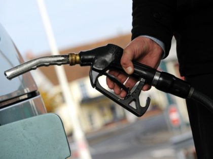 A customer pulls the nozzle of a petrol pump from their car at a petrol station in Egham,