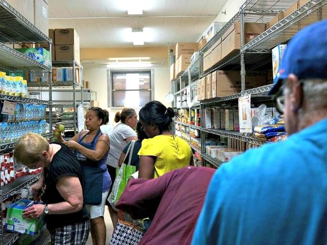 Volunteers help food bank clients in the pantry of the West Side Campaign Against Hunger f