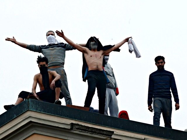 Inmates stand on the roof of the San Vittore prison to protest after restrictions that wer