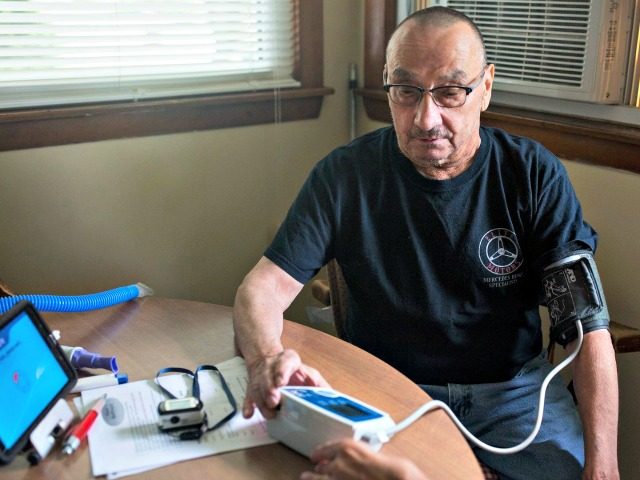 A man measures his vitals and sends the data electronically to nurses. Photo: Brianna Soukup/Portland Portland Press Herald/Getty Images