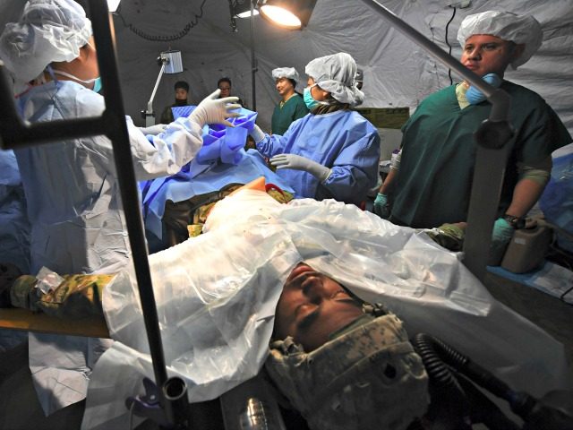 US military medics treat a mock victim in a tent during a joint medical evacuatioin exerci