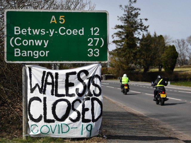 A handmade sign attatched to a road sign near the village of Cerrigydrudion in north Wales on March 23, 2020, declares that due to the Covid 19 virus, "Wales is Closed". - Prime Minister Boris Johnson warned on Sunday he may impose tougher controls on the British public as packed …