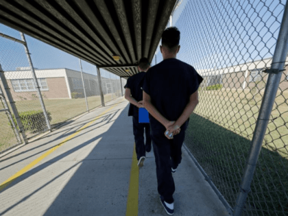 Detainees walk with their hands clasped behind their backs along a line painted on a walkway inside the Winn Correctional Center in Winnfield, La., Thursday, Sept. 26, 2019. Detainees are required to walk from site to site with their hands clasped behind their backs. Since 2018, eight Louisiana jails have …