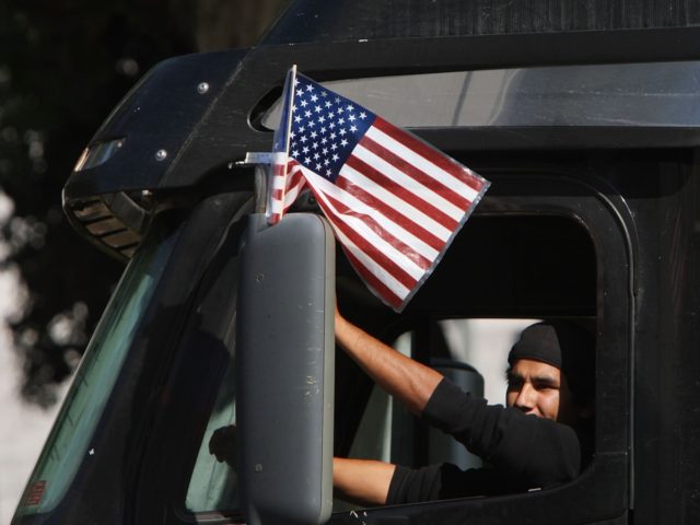 LOS ANGELES, CA - NOVEMBER 13: A trucker drives near City Hall to protest shipping contain