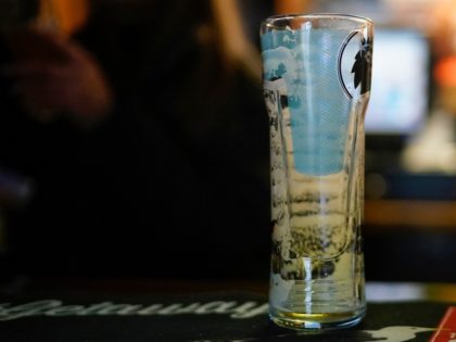 KNUTSFORD, UNITED KINGDOM - MARCH 20: An empty pint glass sits on a bar before the Coronavirus calls time on pubs on March 20, 2020 in Knutsford, United Kingdom. British Prime Minister Boris Johnson announced that the country's bars, pubs, restaurants and cafes must close tonight to curb the spread …