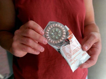390565 01: A woman holds prescription contraceptives June 13, 2001 in Seattle, Washington.