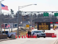 TOPSHOT - US Customs officers stand beside a sign saying that the US border is closed at the US/Canada border in Lansdowne, Ontario, on March 22, 2020. - The United States agreed with Mexico and Canada to restrict non-essential travel because of the coronavirus, COVID-19, outbreak and is planning to …