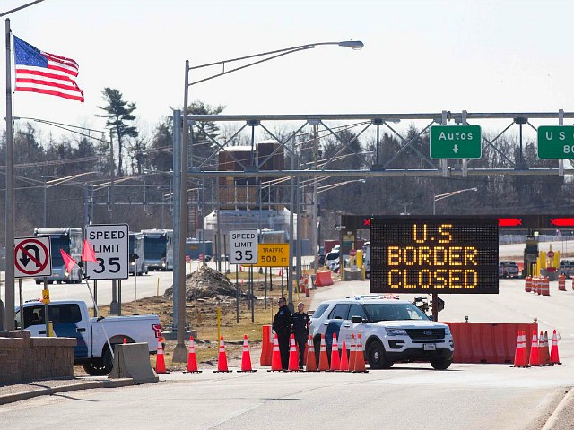 U.S. Customs officers stand beside a sign saying that the U.S. border is closed at the U.S./Canada border in Lansdowne, Ontario, on March 22, 2020. (LARS HAGBERG/AFP via Getty Images)