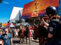 A Mounted Police female officer (R) takes photos of fellow policemen as they patrol on horseback outside the Festival Palace during the 72nd edition of the Cannes Film Festival in Cannes, southern France, on May 14, 2019. (Photo by Laurent EMMANUEL / AFP) (Photo by LAURENT EMMANUEL/AFP via Getty Images)
