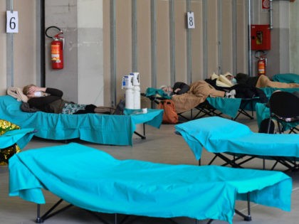 Patients lie in bed at a temporary emergency structure set up outside the accident and emergency department, where any new arrivals presenting suspect new coronavirus symptoms are being tested, at the Brescia hospital, Lombardy, on March 13, 2020. (Photo by Miguel MEDINA / AFP) (Photo by MIGUEL MEDINA/AFP via Getty …