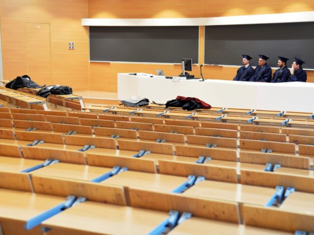 Examiners sit in an empty classroom as they listen to students defending their thesis on l