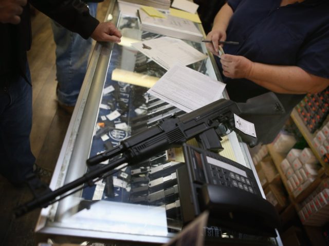 TINLEY PARK, IL - DECEMBER 17: A customer purchases an AK-47 style rifle for about $1200 at Freddie Bear Sports sporting goods store on December 17, 2012 in Tinley Park, Illinois. Americans purchased a record number of guns of guns in 2012. Gun sales have surged recently with people buy …