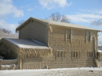 Houses along Hoover Beach are covered by ice from high winds and fifteen foot Lake Erie waves, Saturday, Feb. 29, 2020, in Hamburg N.Y. (AP Photo/Jeffrey T. Barnes)