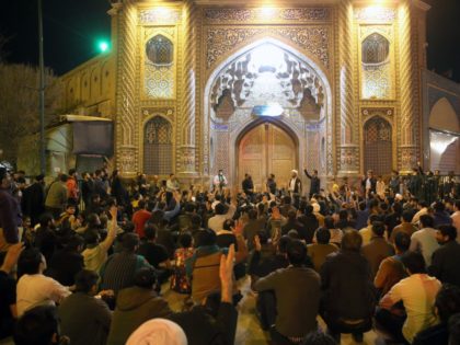 People gather outside the closed doors of the Fatima Masumeh shrine in Iran's holy city of Qom on March 16 2020. - Iran closed four key Shiite pilgrimage sites across the Islamic republic on March 16 in line with measures to stop the spread of the new coronavirus, state media …