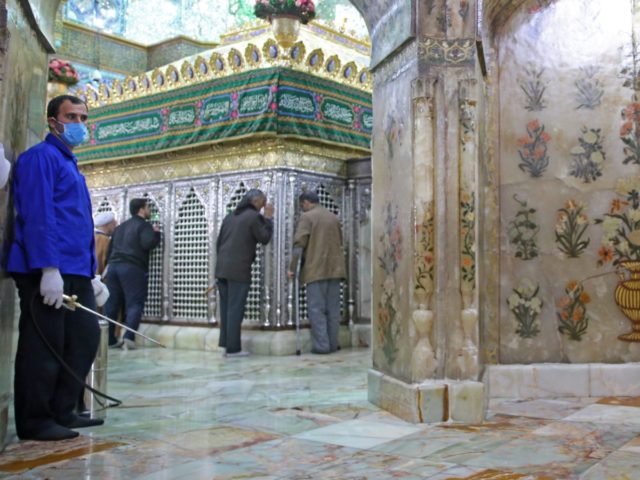 Iranian sanitary workers disinfect Qom's Masumeh shrine on February 25, 2020 to prevent th