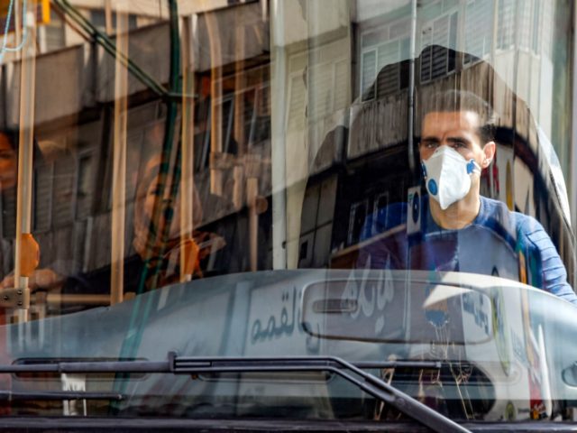 A bus driver wearing a protective mask as a precaution against COVID-19 coronavirus disease operates a bus in Iran's capital Tehran on March 15, 2020. (Photo by STRINGER / AFP) (Photo by STRINGER/AFP via Getty Images)