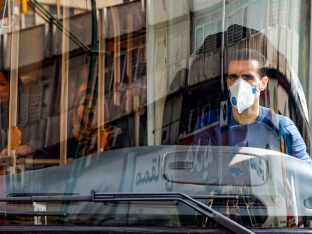 A bus driver wearing a protective mask as a precaution against COVID-19 coronavirus diseas