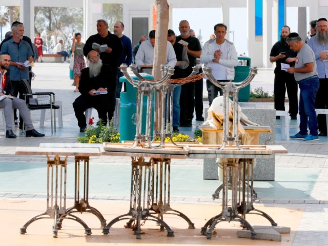 Israeli Jewish worshippers perform midday prayers in the Israeli coastal city of Netanya on March 15, 2020, after Israel shut down eateries, shopping centres and gyms in a bid to halt the spread of novel coronavirus. - The new instructions also prohibit gatherings of over 10 people and advise people …
