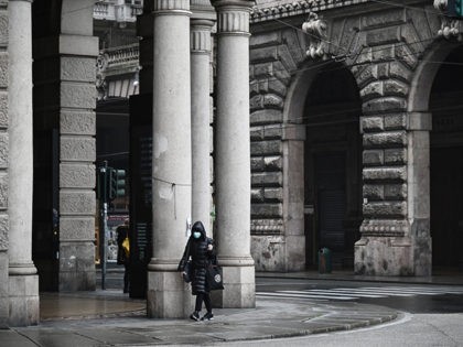 A woman wearing a protection mask walks near Piazza de Ferrari in Genoa, Liguria, on March