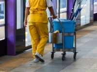 maid working with janitorial mop bucket car.