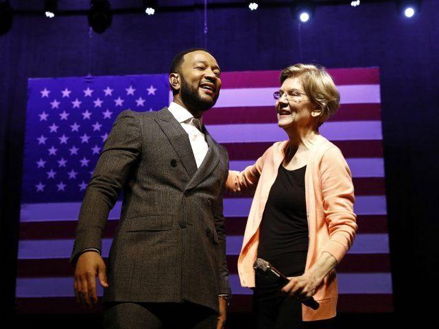 Democratic presidential candidate Sen. Elizabeth Warren, D-Mass., embraces performer John