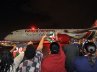 People wave Kenyan flags as a Boeing 787-Dreamliner of Kenya Airways taxis out to the runway following a flag-off ceremony attended by the Kenyan President as it embarks on the airline's first ever non-stop flight from Jomo Kenyatta International Airport in Nairobi to New York on October 28, 2018. - …