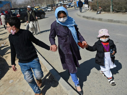 A woman with children wearing facemasks as a protective measure against the spread of the COVID-19 coronavirus, walk along a street in Kabul on March 18,2020. (Photo by WAKIL KOHSAR / AFP) (Photo by WAKIL KOHSAR/AFP via Getty Images)