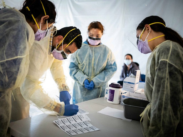 NEW YORK, NY - MARCH 24: Doctors test hospital staff with flu-like symptoms for coronavirus (COVID-19) in set-up tents to triage possible COVID-19 patients outside before they enter the main Emergency department area at St. Barnabas hospital in the Bronx on March 24, 2020 in New York City. New York …