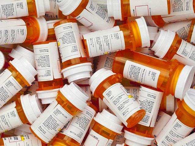 Dozens of prescription medicine bottles in a jumble. This collection of pill bottles is symbolic of the many medications senior adults and chronically ill people take.