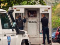 Police agents transport surviving prisoners after police holding cells caught fire in Valencia, northern Carabobo state, Venezuela, on March 29, 2018. A total of 68 people died on Wednesday during an attempted jailbreak in Venezuela after a fire engulfed police holding cells in one of the worst tragedies in years …