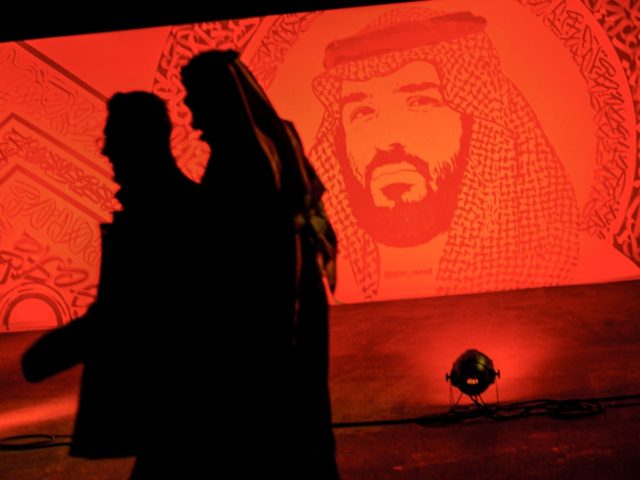 A picture taken on January 31, 2020 shows young Saudis walking next to a portrait of Crown Prince Mohammed bin Salman at the Riyadh Season Boulevard in the Saudi capital. - In Saudi Arabia's rigid past, religious police once swooped down on rose sellers and anyone peddling red paraphernalia around …
