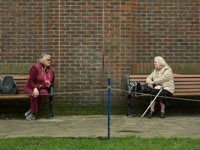 TOPSHOT - Two women observe social distancing measures as they speak to each other from adjacent park benches amidst the novel coronavirus COVID-19 pandemic, in the centre of York, northern England on March 19, 2020. (Photo by OLI SCARFF / AFP) (Photo by OLI SCARFF/AFP via Getty Images)