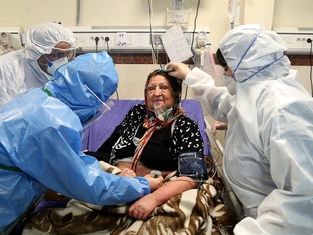 Medics treat a patient infected with the new coronavirus, at a hospital in Tehran, Iran, S