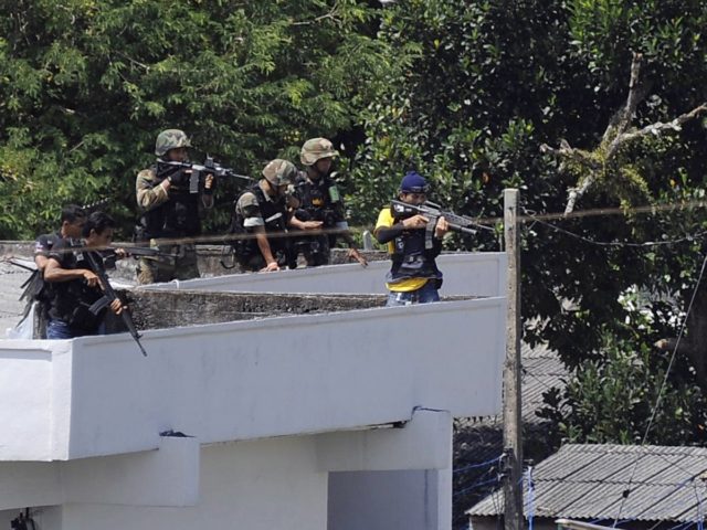 Thai snipers aim rifles to control a situation during a prison riot in Narathiwat province