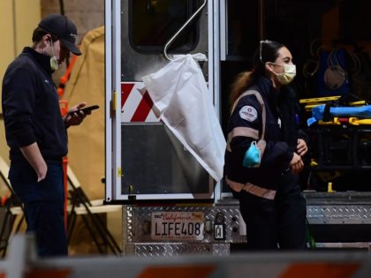 Paramedics wearing facemasks work behind an ambulance at the Garfield Medical Center in Monterey Park, California on March 19, 2020. - All residents of California were ordered to stay at home March 19, 2020, in a bid to battle the coronavirus pandemic in the most populous state in the US. …