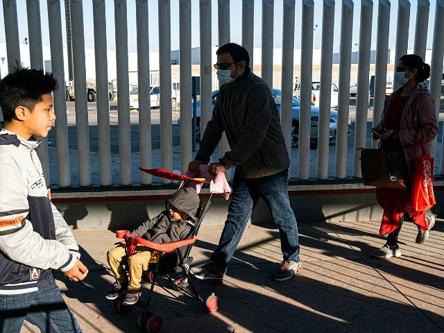 Asylum seekers wearing protective masks walk towards their appointment with US authorities at El Chaparral crossing port on the US/Mexico Border in Tijuana, Baja California state, Mexico, on February 29, 2020. - Mexico's Health Ministry confirmed the country's third case of coronavirus. (Photo by Guillermo Arias / AFP) (Photo by …