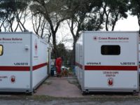 ROME, ITALY - MARCH 17: A member of the Italian Red Cross plays with a dog between two field kitchens in the headquarters of the Red Cross on March 17, 2020 in Rome, Italy. Homeless people are trapped in still cities, many assistance centers are closed due to possible contagion, …