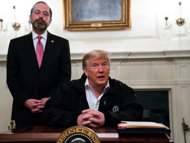 Secretary of Health and Human Services Alex Azar listens as President Donald Trump talks to reporters during a signing of a spending bill to combat the coronavirus, at the White House, Friday, March 6, 2020, in Washington. (AP Photo/Evan Vucci)