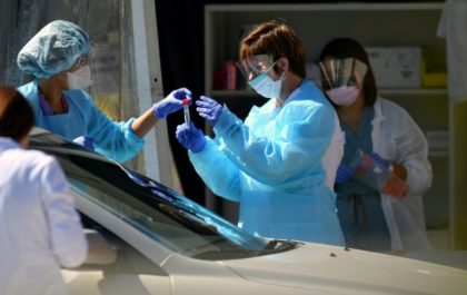 Medical workers at a Kaiser Permanente French Campus test a patient for the novel coronavirus, COVID-19, at a drive-thru testing facility in San Francisco on March 12 San Francisco area residents ordered to stay home