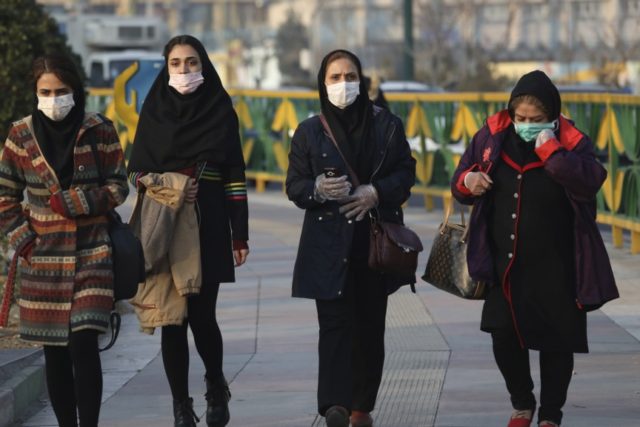 Virus Outbreak Mideast Iran Pedestrians wearing face masks walk on a sidewalk in western Tehran, Iran, Saturday, Feb. 29, 2020. Iran is preparing for the possibility of "tens of thousands" of people getting tested for the new coronavirus as the number of confirmed cases spiked again Saturday, Health Ministry spokesman Kianoush Jahanpour said, underscoring the fear both at home and abroad over the outbreak in the Islamic Republic. (AP Photo/Vahid Salemi) The Associated Press