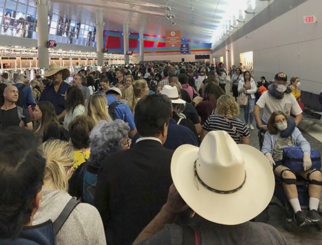 In this photo provided by Austin Boschen, people wait in line to go through the customs at Dallas Fort Worth International Airport in Grapevine, Texas, Saturday, March 14, 2020. International travelers reported long lines at the customs at the airport Saturday as staff took extra precautions to guard against the …