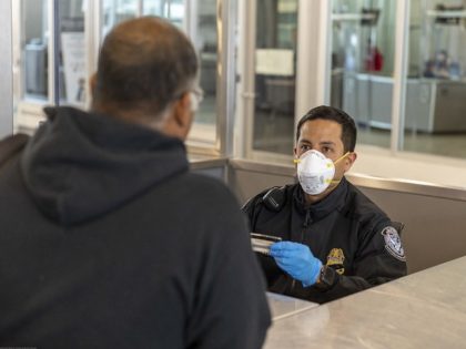 CBP officer at San Ydidro Port of Entry interviews a traveler while wearing PPE. (File Photo: U.S. Customs and Border Protection/Mani Albrecht)